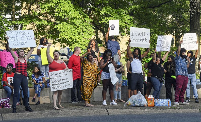 People standing in street in protest, holding up signs