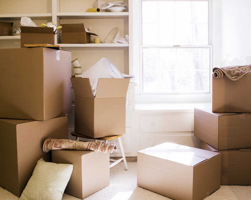 Brown packing boxes stacked up in front of a window